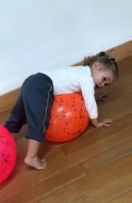 Criança brincando com uma bola grande